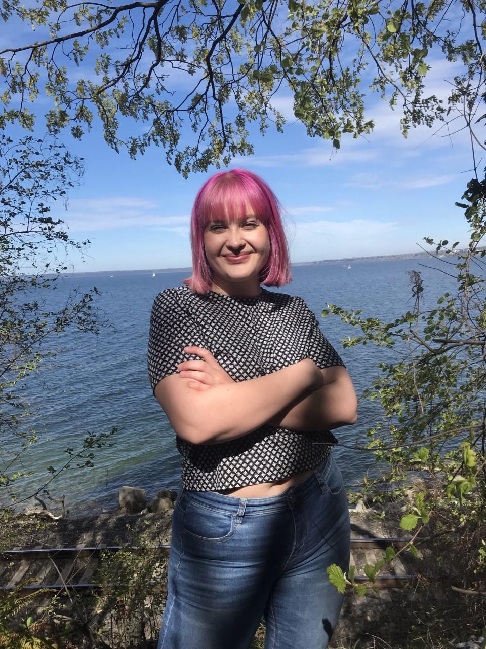 Shannon stands with arms crossed in front of Bellingham Bay