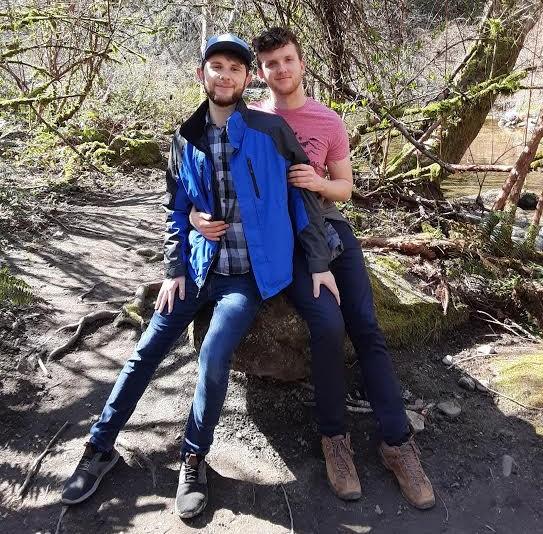 Turner and Zach pose together on a log