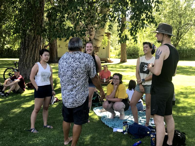 A group of students gathers around an instructor at a Methow Valley park