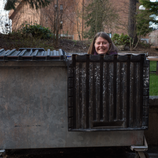 Gwen Larned peeks out from a dumpster